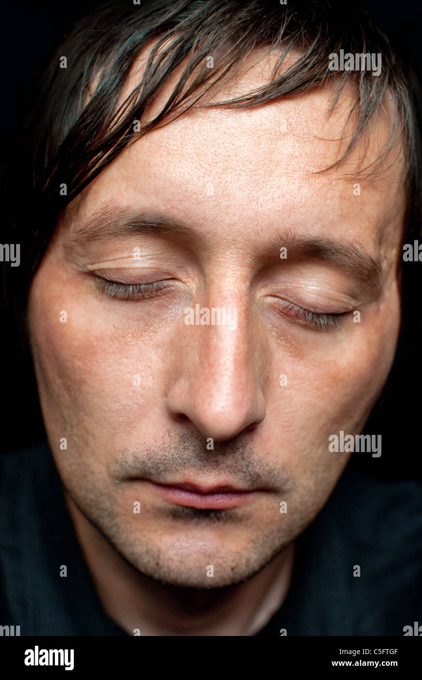 Close up low key ritratto di un maschio adulto sleeping Foto Stock