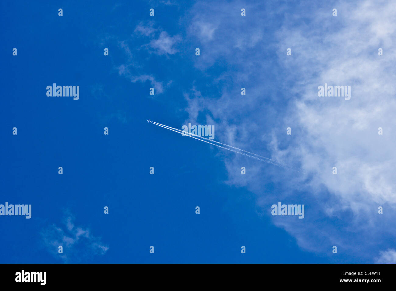 Jet contrail (vapor trail) nel cielo blu con nuvole Foto Stock