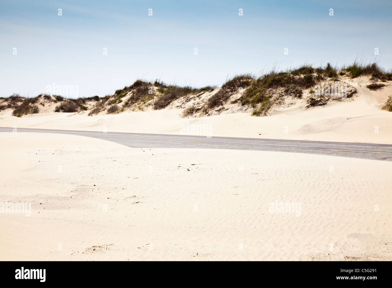 Texas Park Road 100 con sabbia soffiando sulle dune di sabbia su South Padre Island nel sud del Texas. Foto Stock