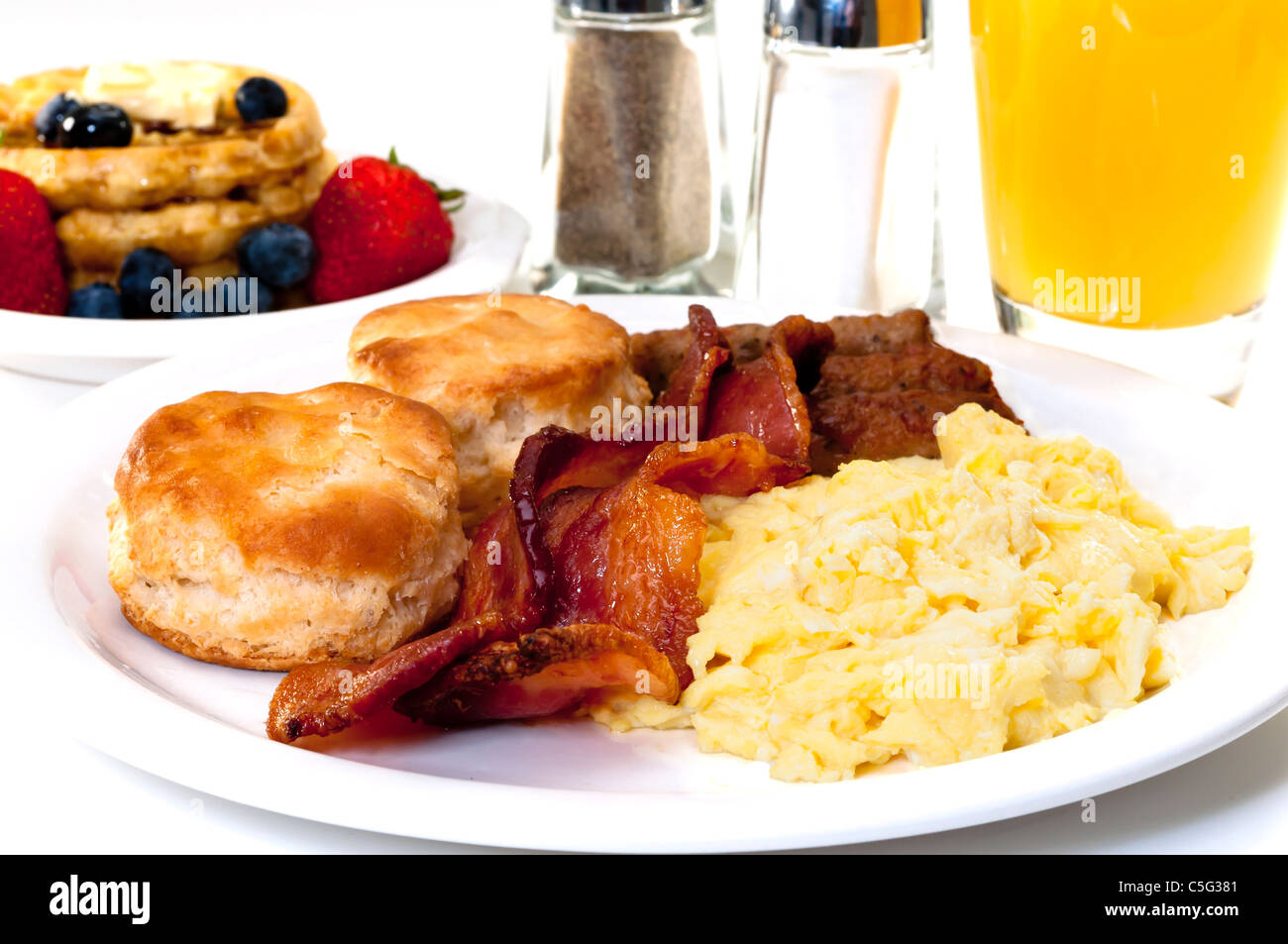 Paese grande colazione con uova strapazzate, bacon, latticello biscotti, cialde, frutta e succo di arancia. Foto Stock