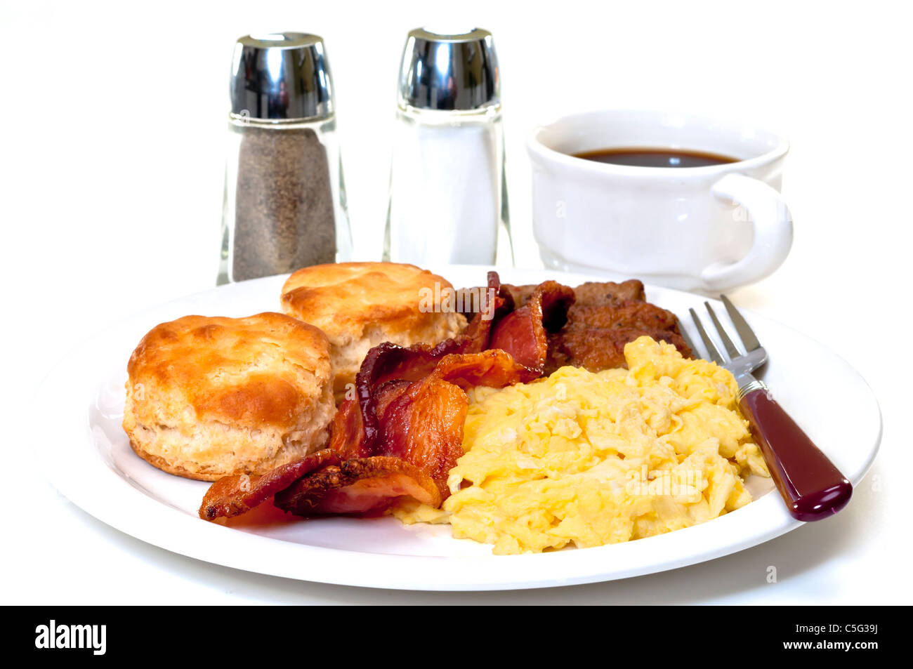Paese grande colazione con uova strapazzate, bacon, salsicce, latticello biscotti e caffè. Il sale e il pepe. Foto Stock