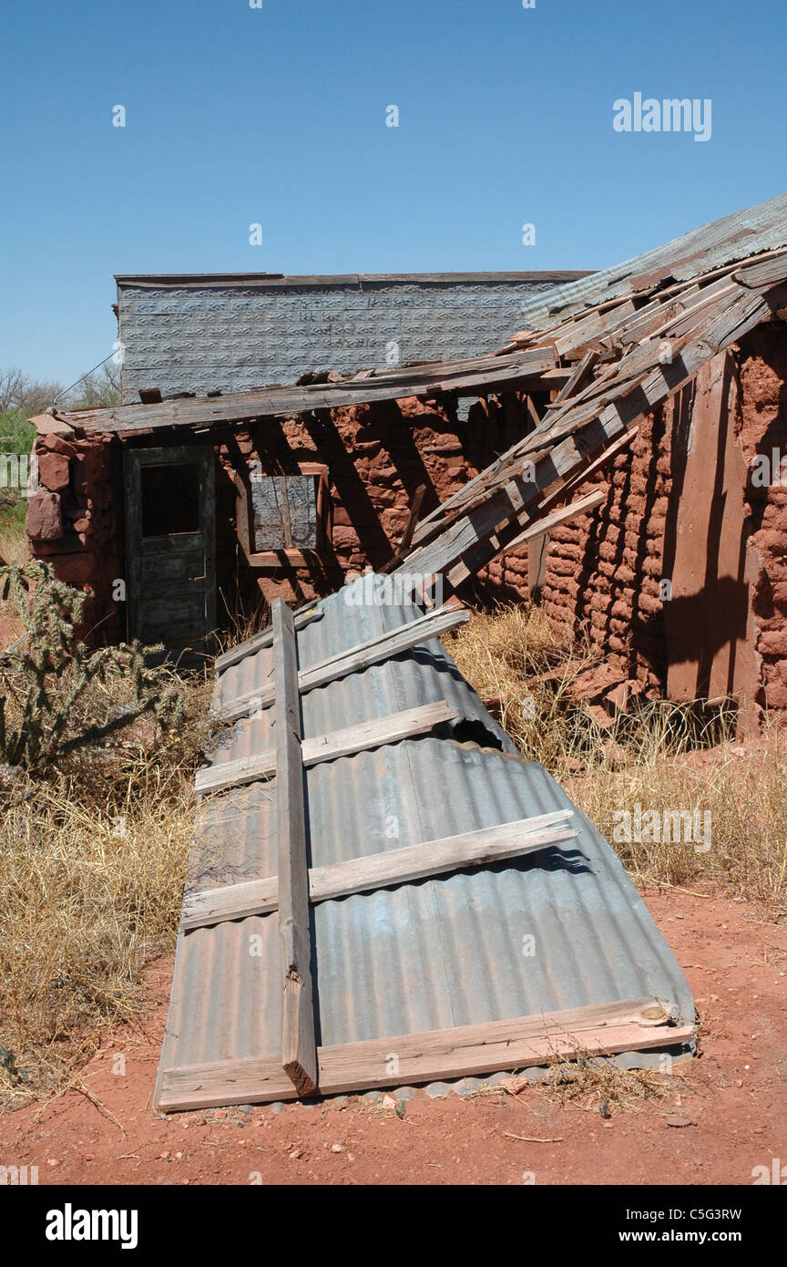 Il tetto di uno sbriciolamento stucco e mattoni di fango farm house si trova dietro la casa in Cuervo New Mexico. Foto Stock