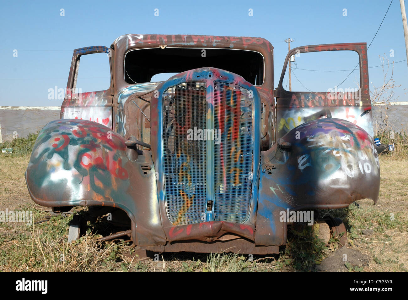 Questa 1933 Ford Coupe è un bersaglio per atti di vandalismo da parte di persone che pilotano il passato. La vettura si trova lungo la route 66 vicino a Amarillo. Foto Stock