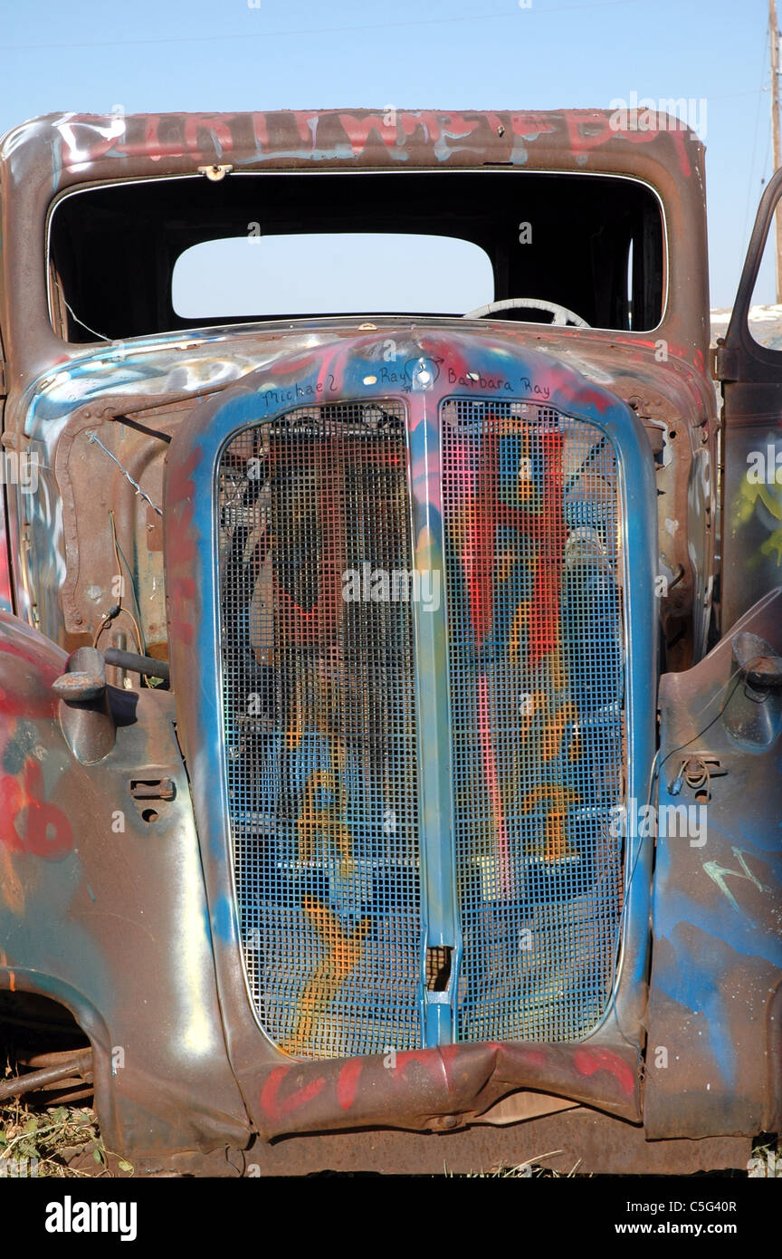 La griglia di un 1933 Ford Coupe è un bersaglio per atti di vandalismo da parte di persone che pilotano il passato. La vettura si trova lungo la route 66 vicino a Amarillo. Foto Stock
