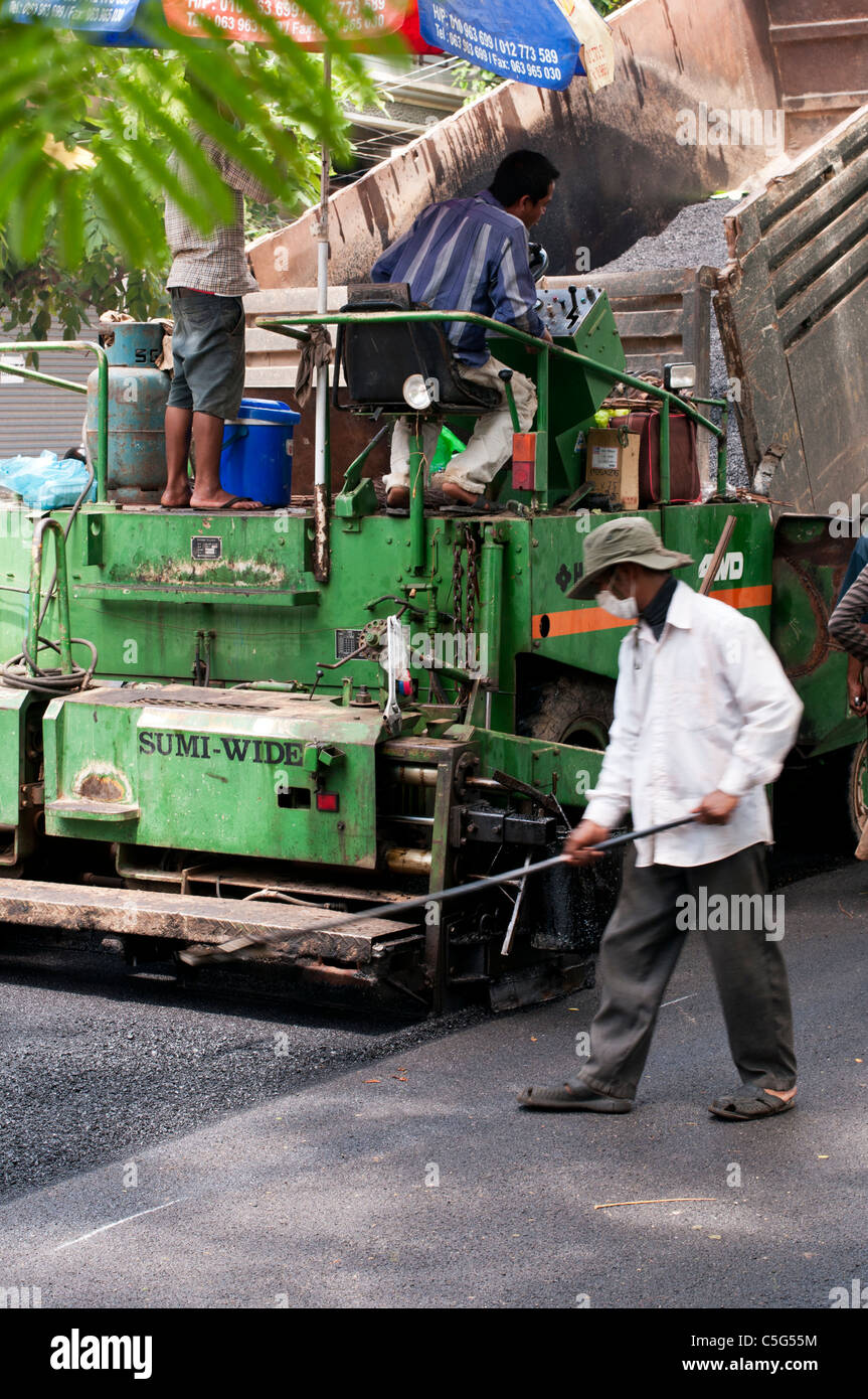 Strada pista lavoratori posa nuovo manto stradale in Somdech Tep Vong St, Siem Reap, Cambogia Foto Stock