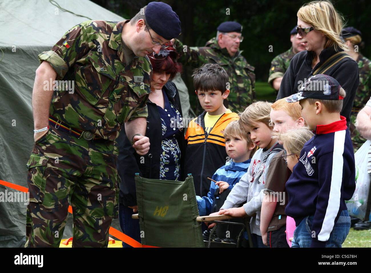 Soldato dimostrando attrezzature per bambini. Foto Stock