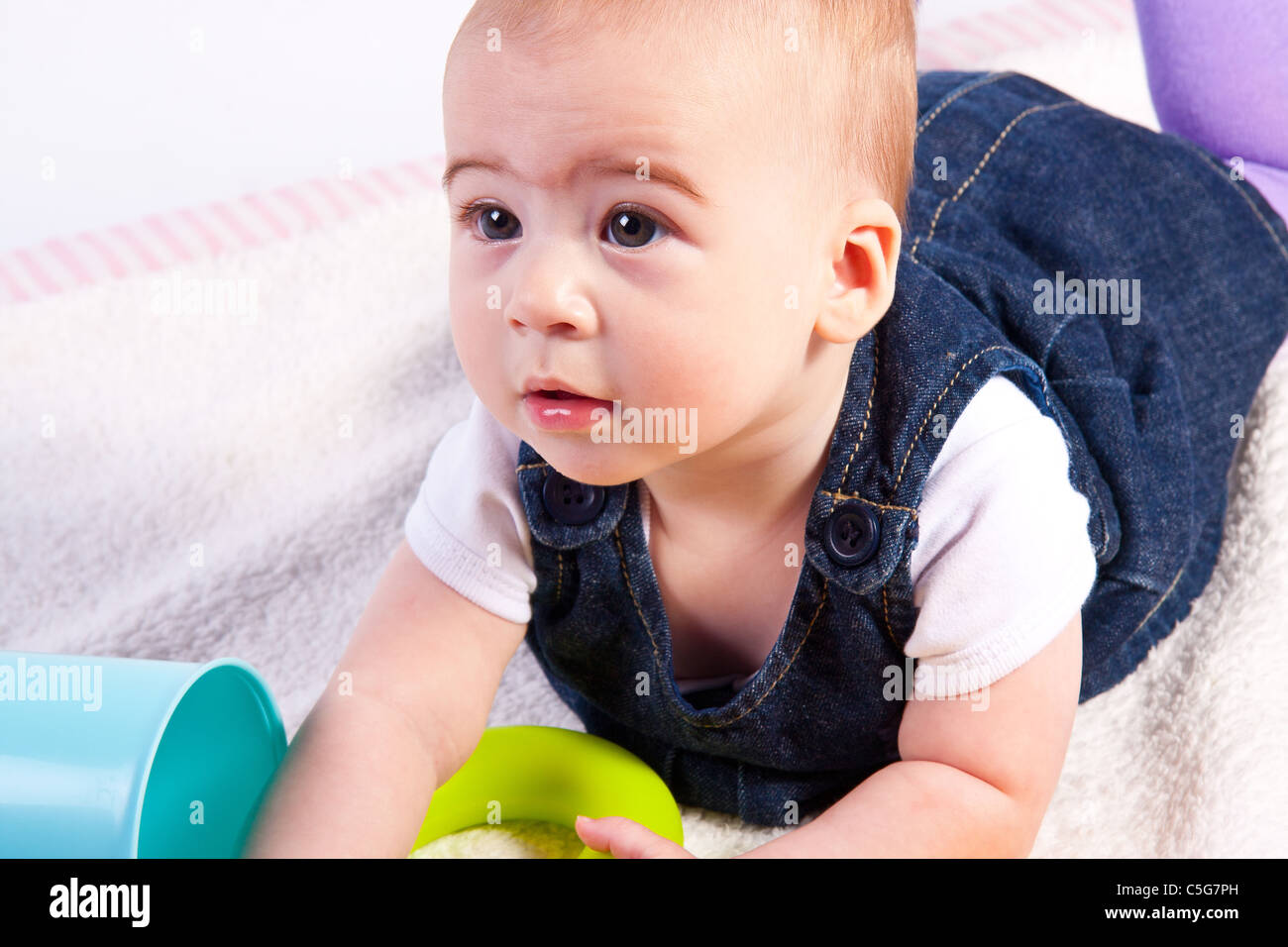 Bambino di 6 mesi ragazza che gioca con giocattoli colorati isolato su bianco Foto Stock