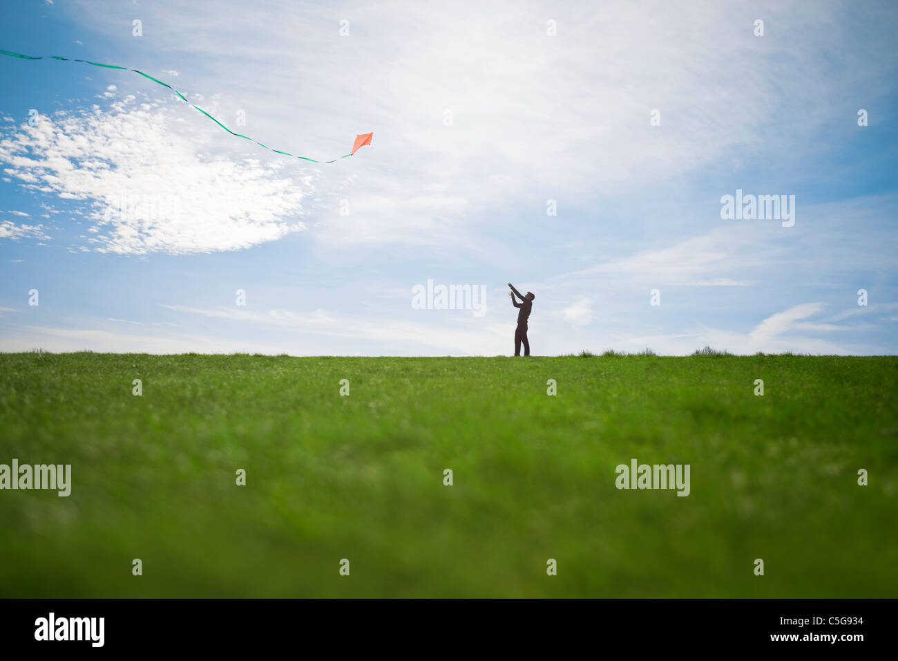 Un uomo volare un aquilone rosso Foto Stock