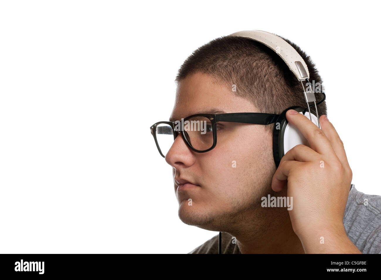 Un giovane uomo ascolta musica con una serie di telefoni di testa mentre esaminando l'album sulla custodia del CD. Foto Stock