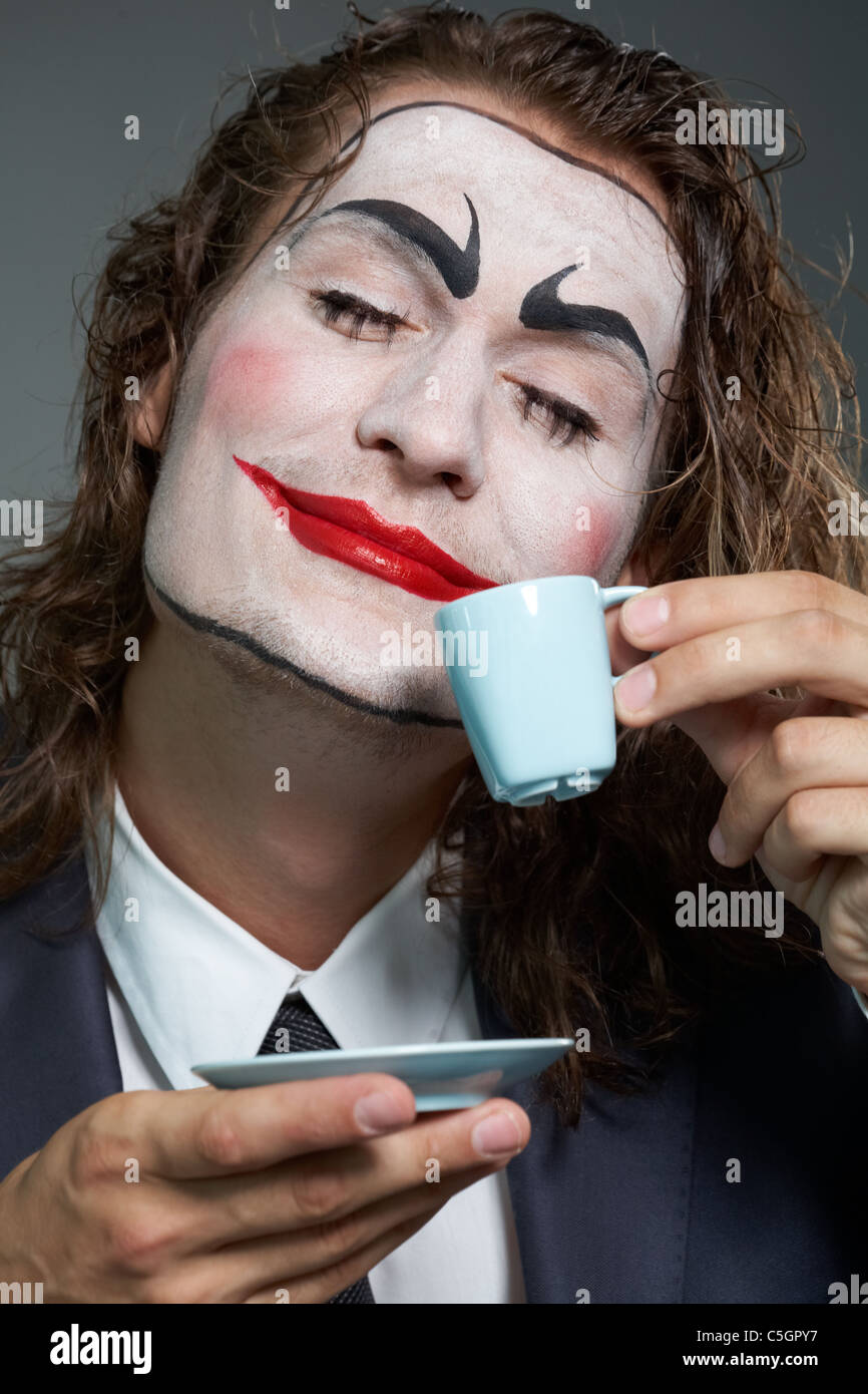 Ritratto di imprenditore con faccia dipinta di bere il caffè Foto Stock