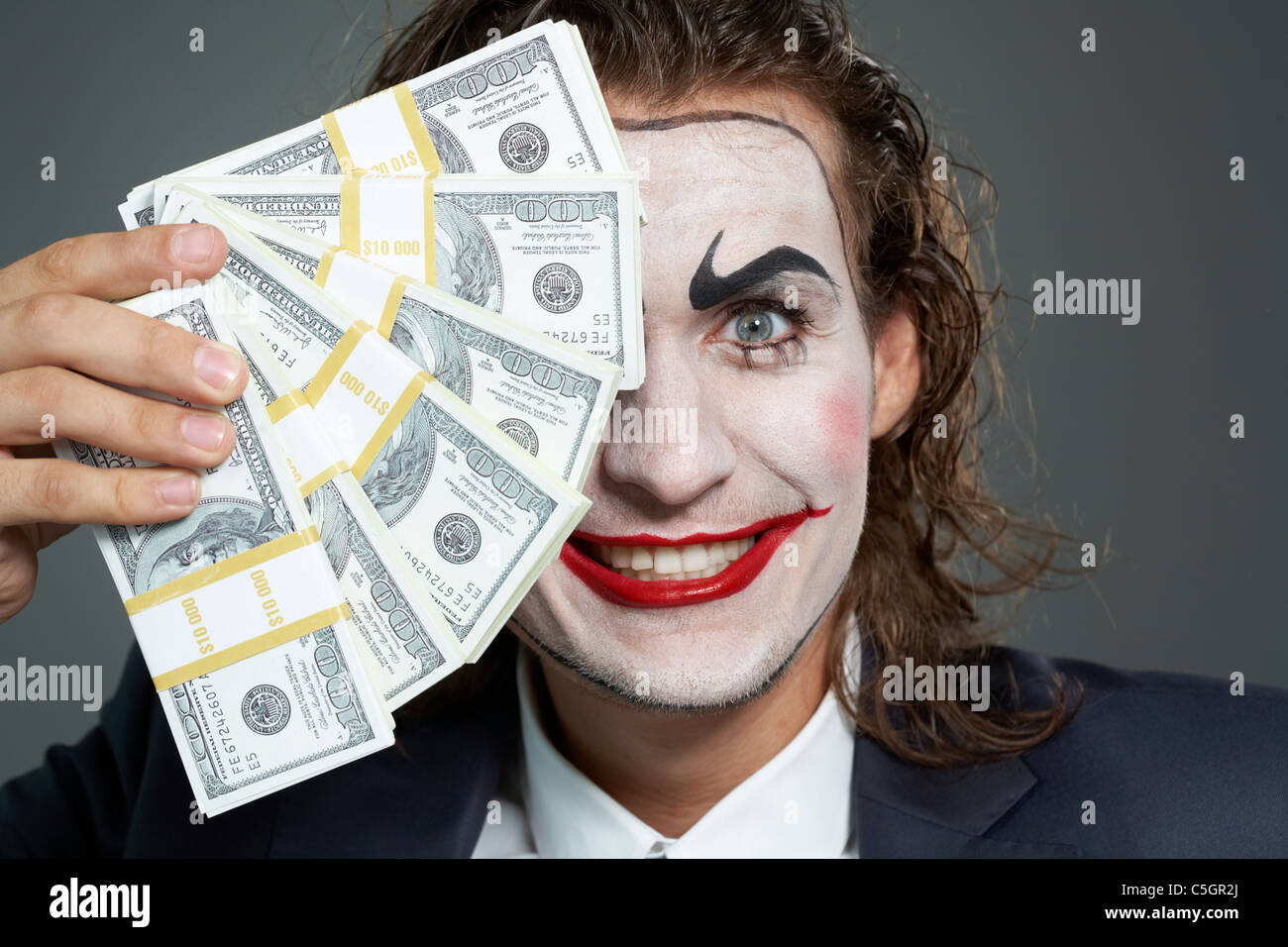 Ritratto di uomo con faccia dipinta holding banconote Foto Stock