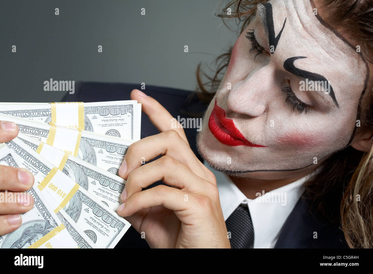 Ritratto di uomo con faccia dipinta conteggio banconote Foto Stock