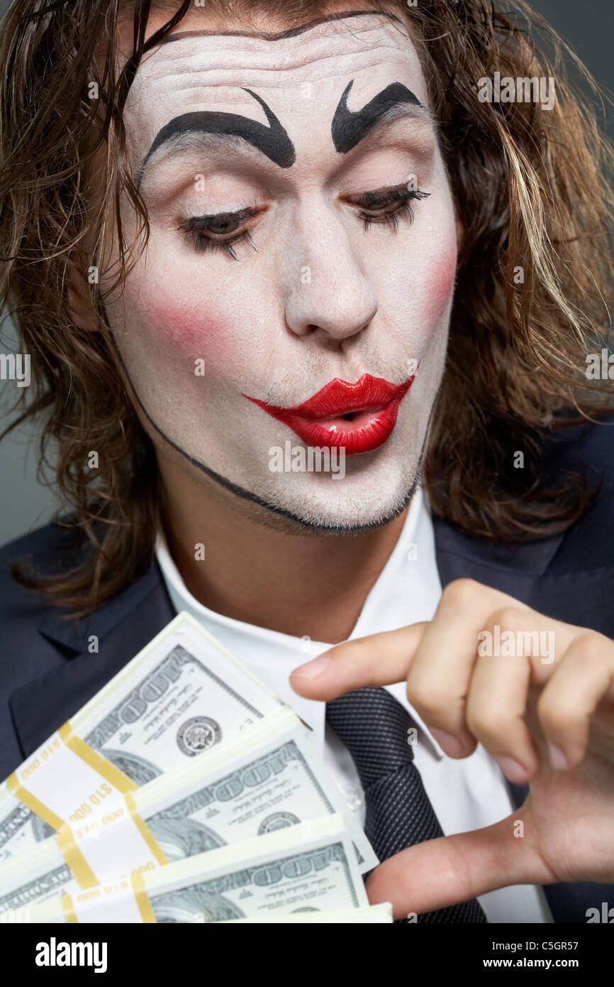 Ritratto di uomo con faccia dipinta con carta moneta Foto Stock