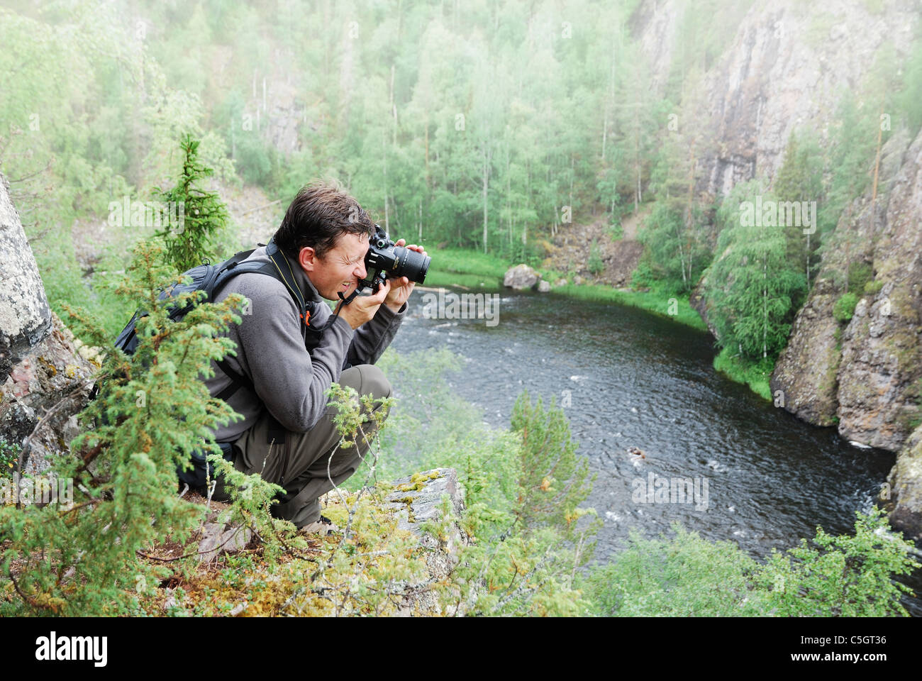 Uomo di fotografare sulla parte superiore della taiga forest. Foto Stock