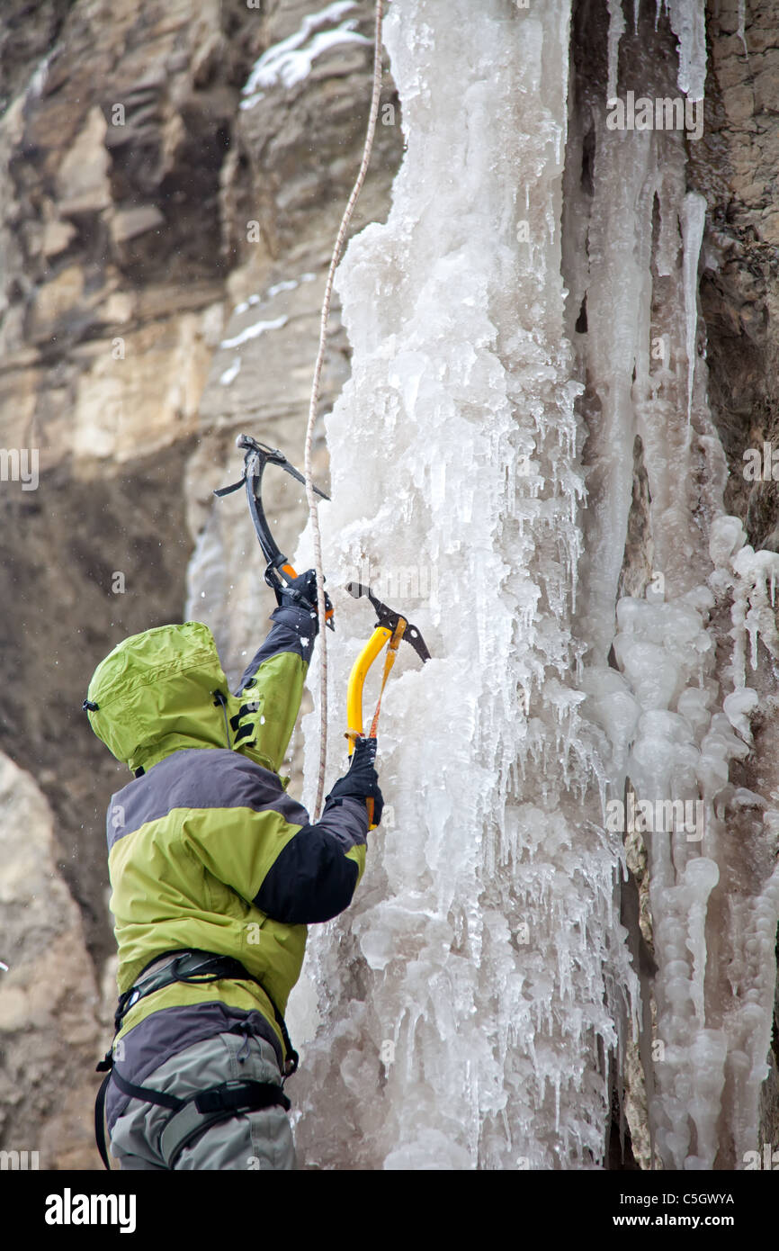 Uomo con assi di ice climbing sul ghiacciaio Foto Stock