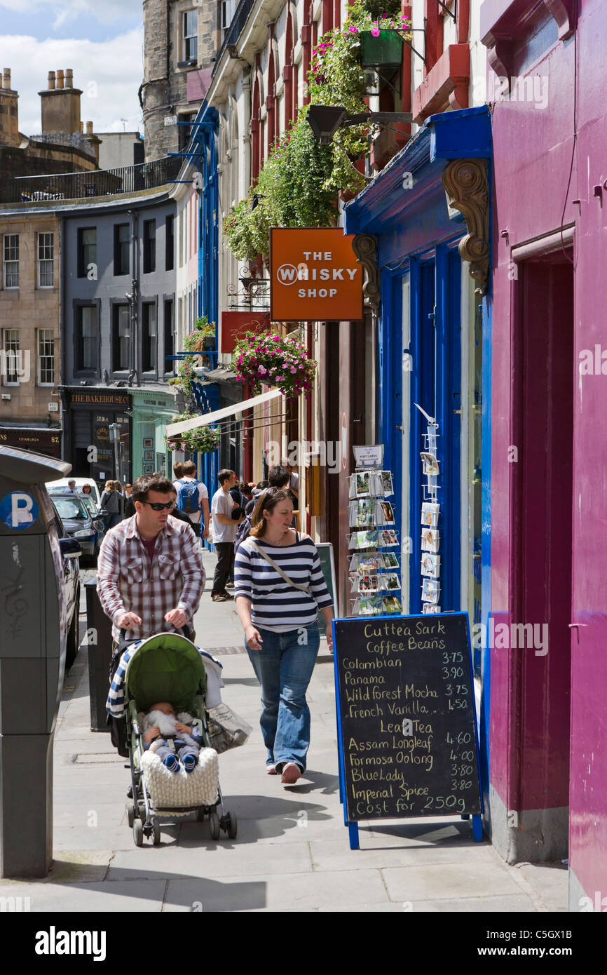 Giovane con bambino passato a piedi negozi sul Grassmarket nel centro storico di Edimburgo, Scozia, Regno Unito Foto Stock
