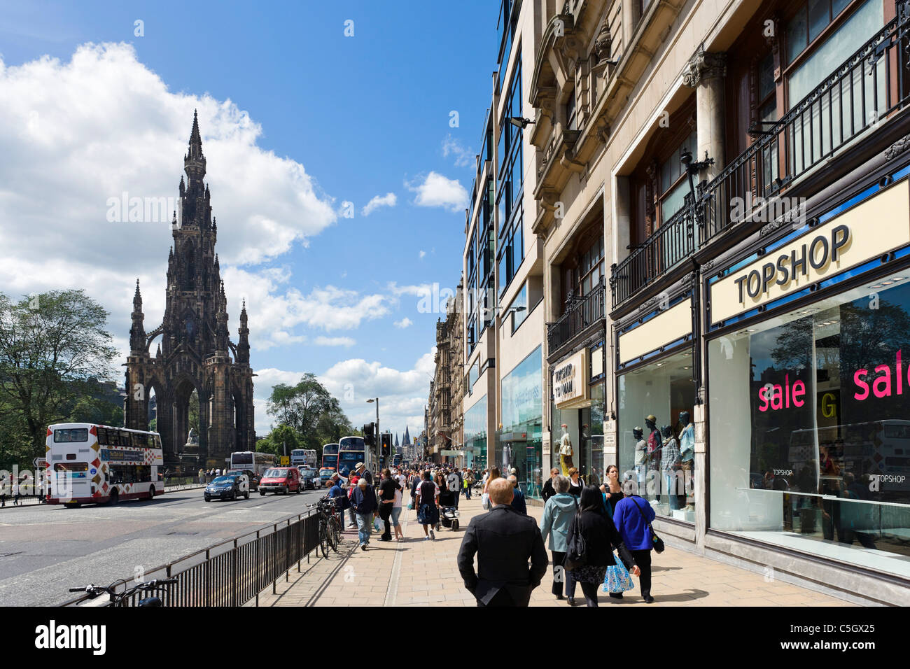 Negozi e shopperts in corrispondenza della estremità superiore di Princes Street con il Monumento di Scott a sinistra, Edimburgo, Scozia, Regno Unito Foto Stock