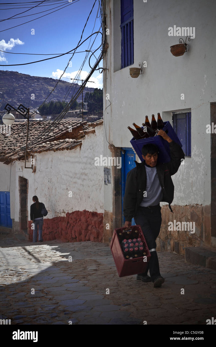 Scena di strada : l uomo che trasportano casse di bottiglie di birra Cuzco, favela, Ande Perù Cusco e Machu Picchu, Ande, Sud America Foto Stock