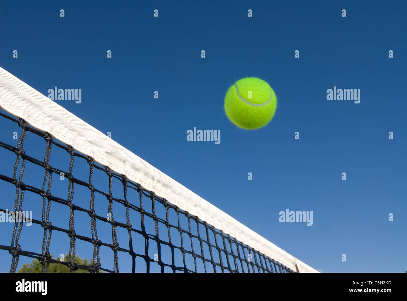 Un'immagine raffigurante il concetto di tennis, compresa una pallina di scorrimento sul net in un blu impostazione esterna Foto Stock