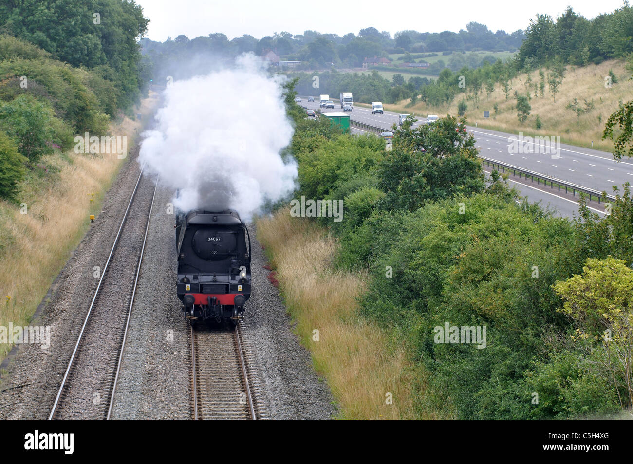 Treno a vapore sulla linea ferroviaria accanto all'autostrada M40, Warwickshire, Regno Unito Foto Stock