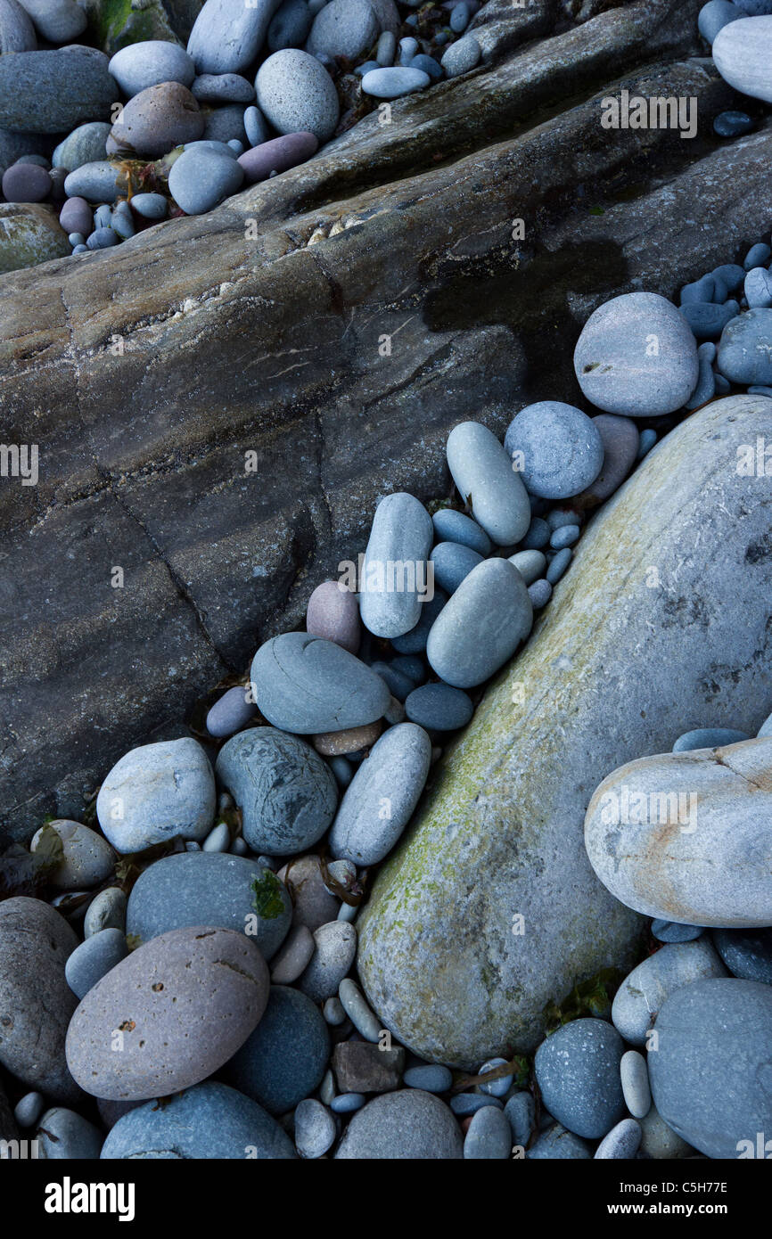 Blu grigio rocce e ciottoli rotondi sulla spiaggia rocciosa, Glasnakille, Isola di Skye, Scotland, Regno Unito Foto Stock