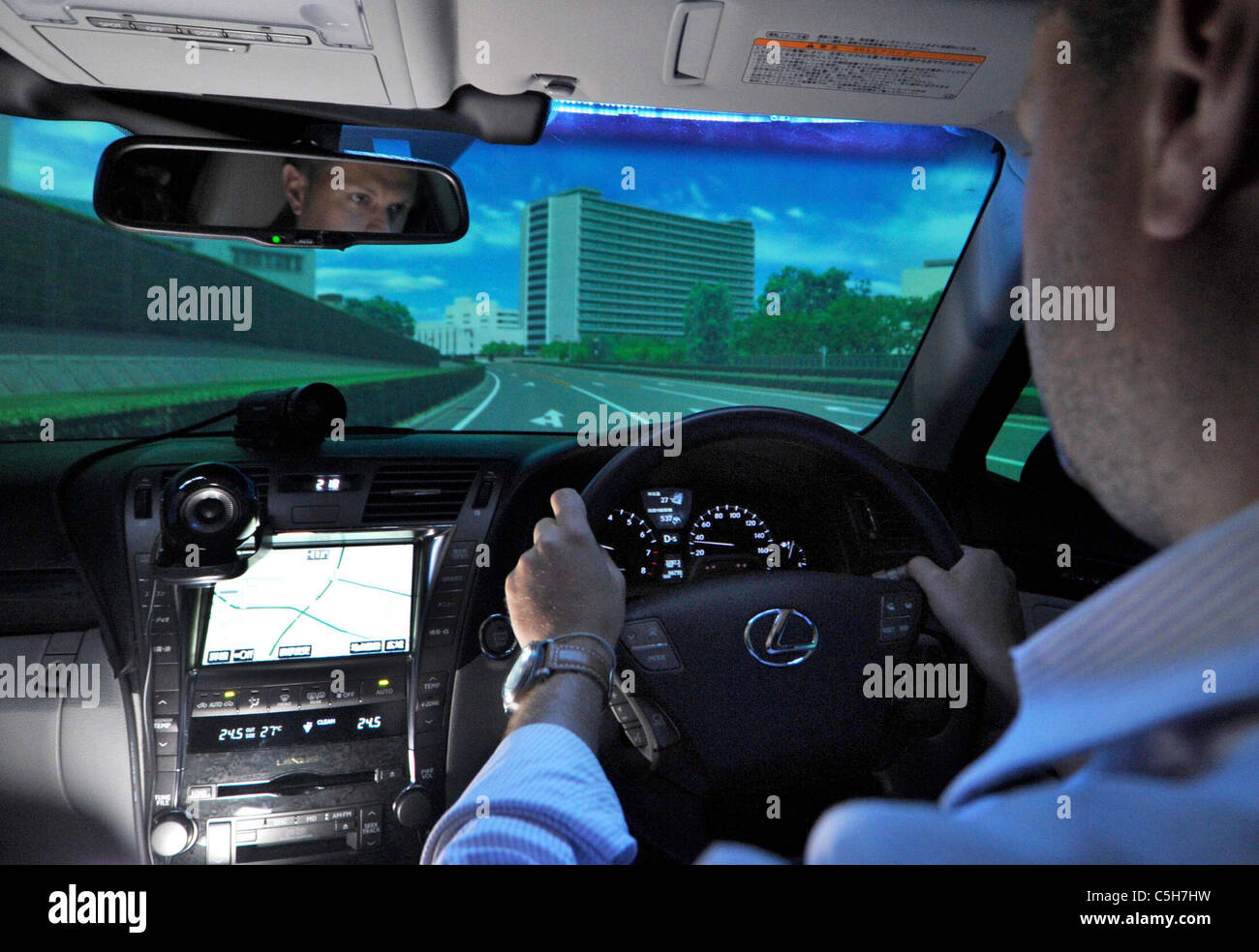 Una visita a reporter si siede dietro al volante di un simulatore di guida a Toyotas Higashi-Fuji centro tecnico. Foto Stock