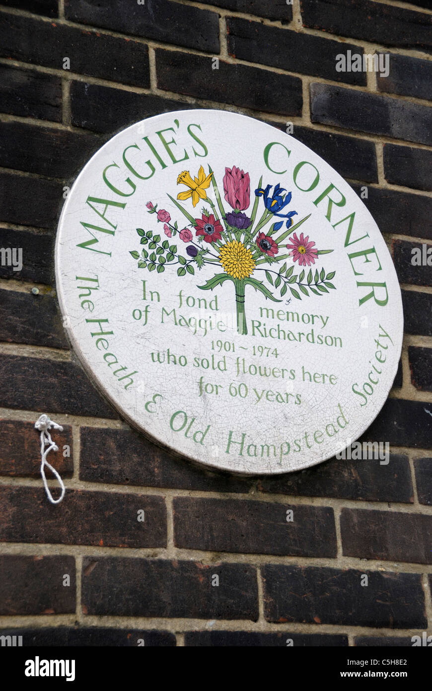 Maggie's Corner placca, Hampstead, Londra, Inghilterra. In memoria di Maggie Richardson che vendeva fiori in questo posto per 60 anni. Foto Stock