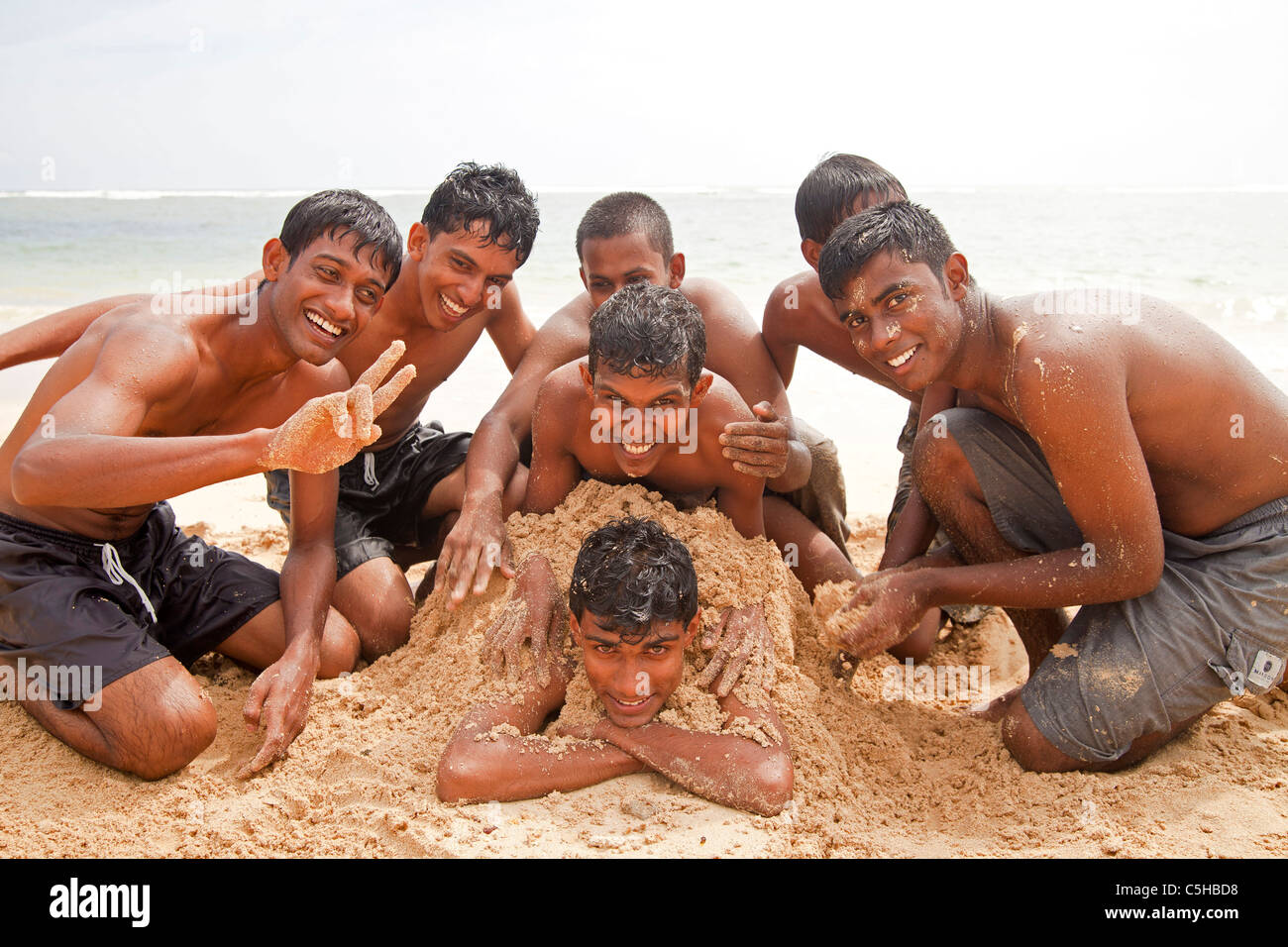 La gioventù divertirsi nella sabbia in spiaggia in Polhena, Matara, LKA, Sri Lanka Foto Stock