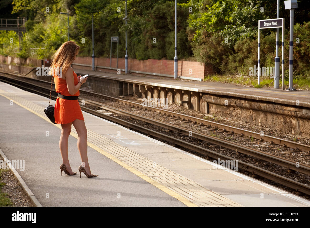 Giovane donna in attesa di un treno, Elmstead Woods, stazione treni sud-orientale, London REGNO UNITO Foto Stock