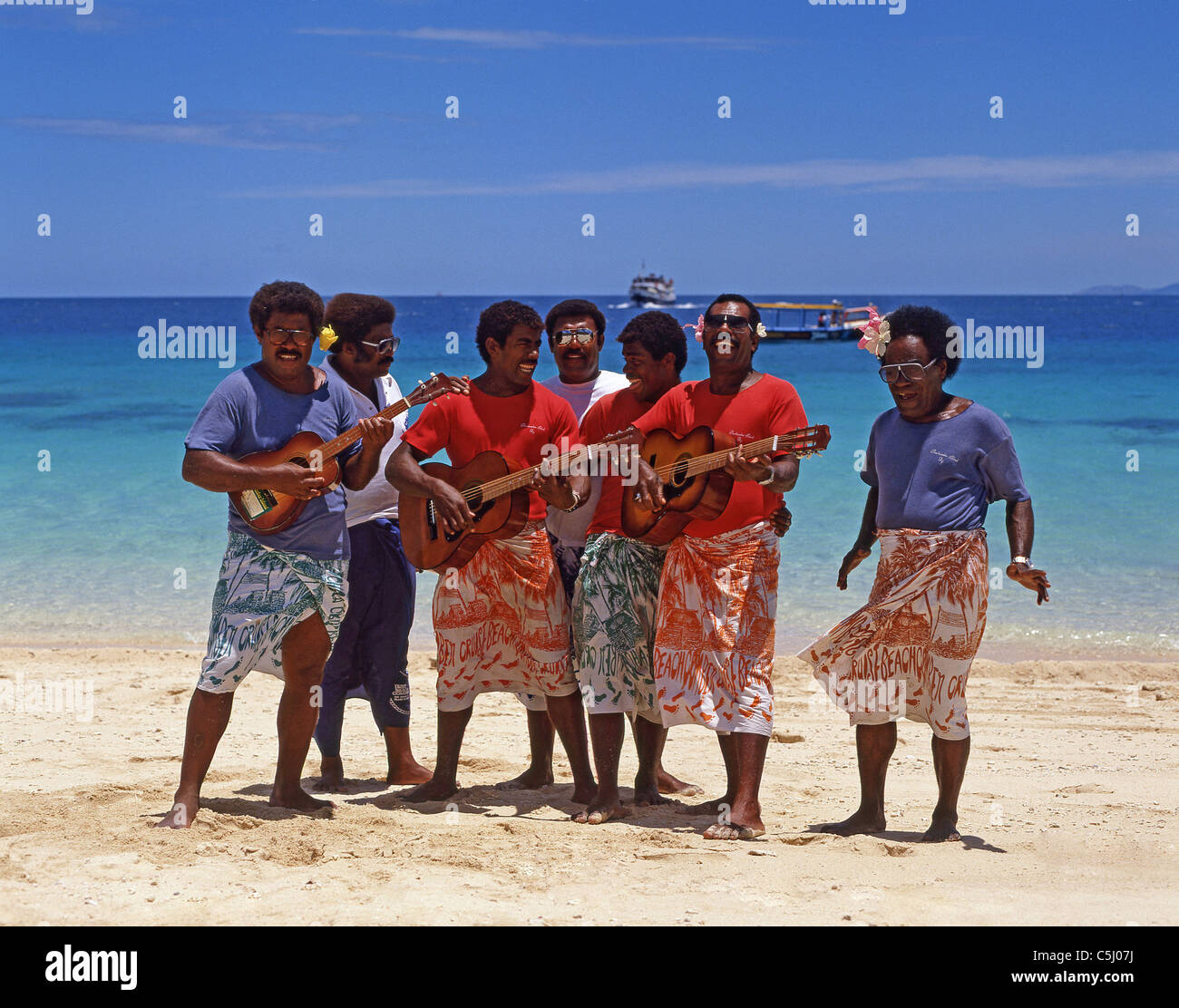 Fijian welcome party sulla spiaggia, isola di Beachcomber Resort, Isole della Mamanuca, Viti Levu, Repubblica delle Isole Figi Foto Stock