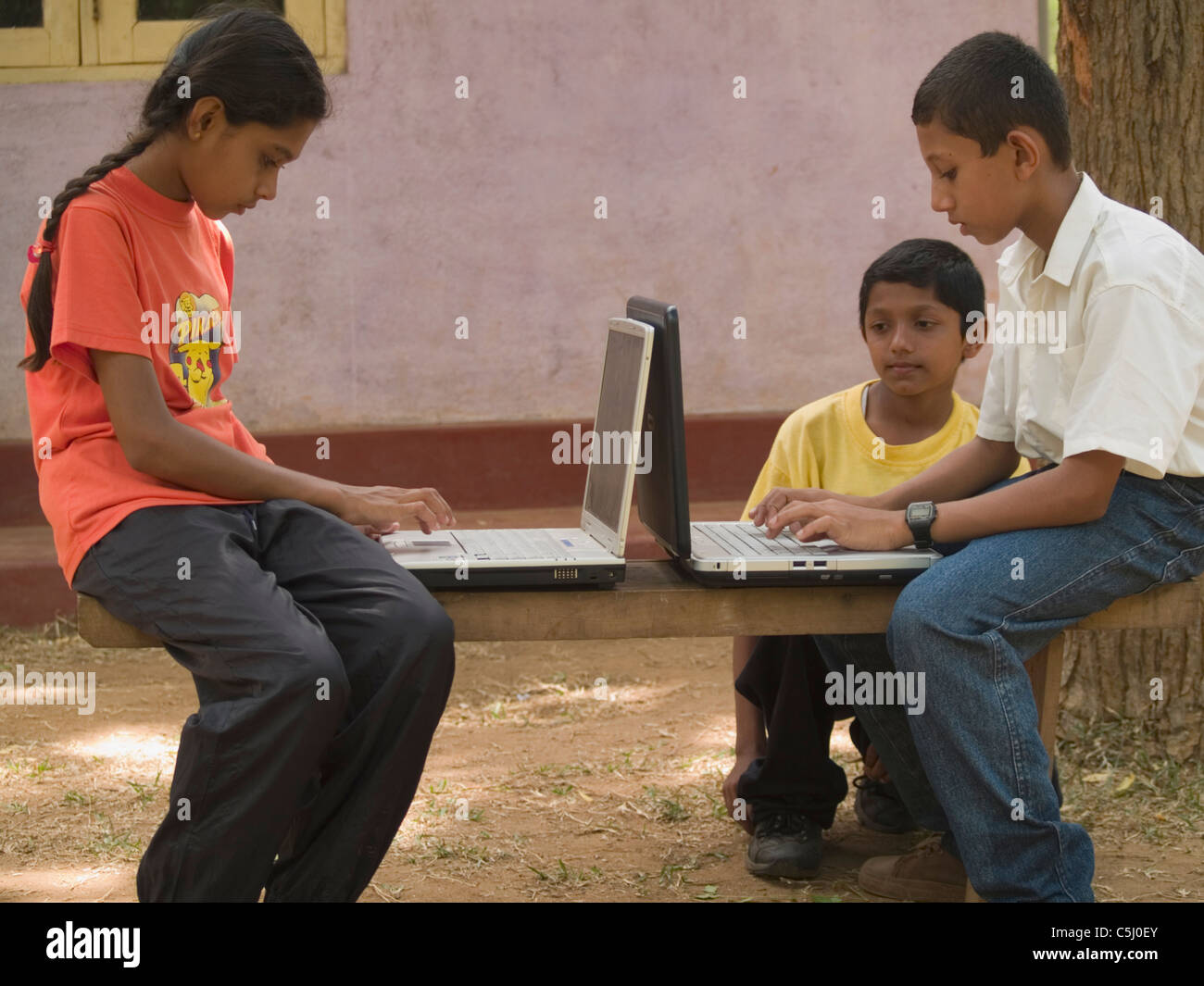 Gli studenti della scuola elementare utilizzando computer presso la scuola del villaggio corrono attraverso orizzonte Lanka Foundation in Mahavilachchiya, Sri Foto Stock