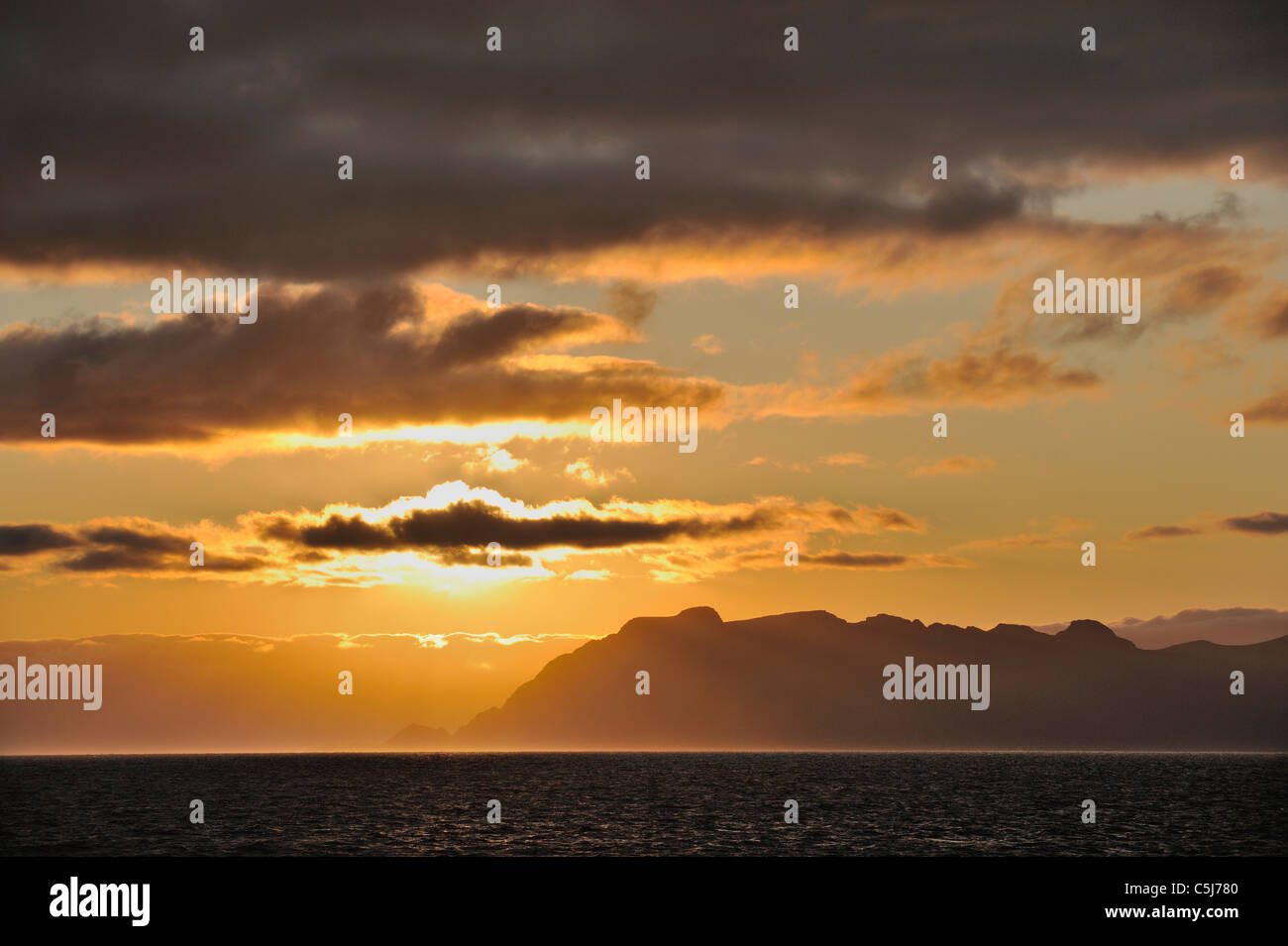 Oceanic tramonto con il sud delle isole Lofoten all'orizzonte, a nord-ovest della Norvegia. Foto Stock