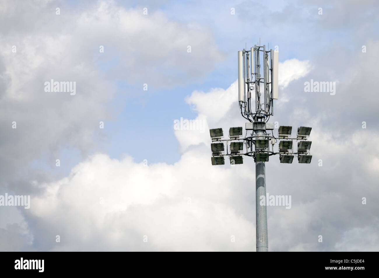 Telefono cellulare antenna (montante) trasmettitore su uno stadio di calcio Luce proiettore Foto Stock