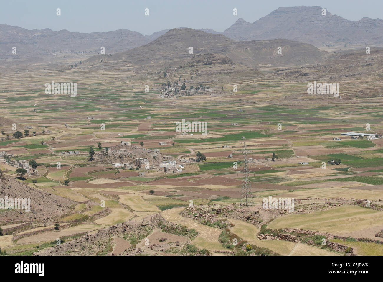 Pendio terrazzato in Yemen con un villaggio della valle Foto Stock
