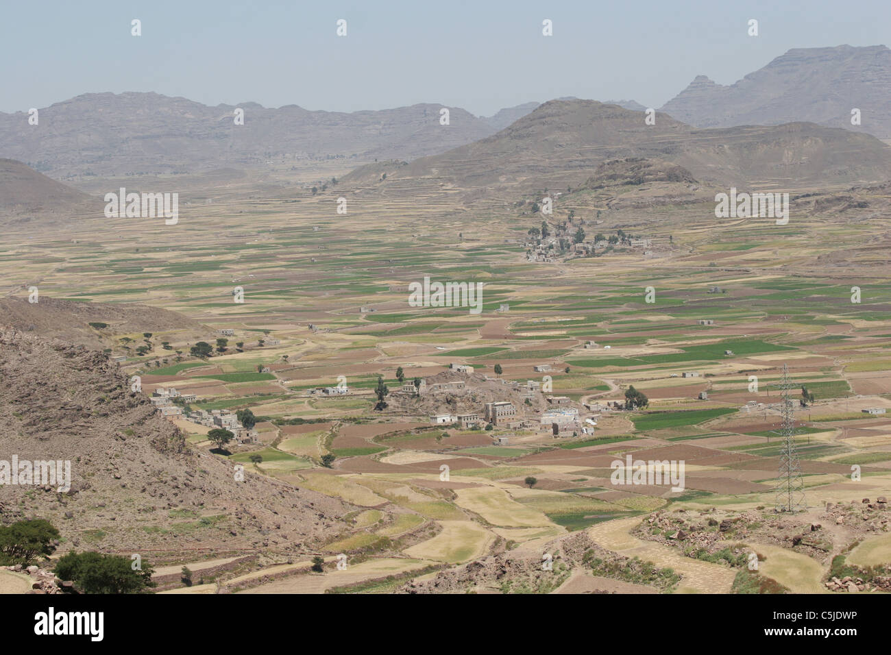 Pendio terrazzato in Yemen con un villaggio della valle Foto Stock