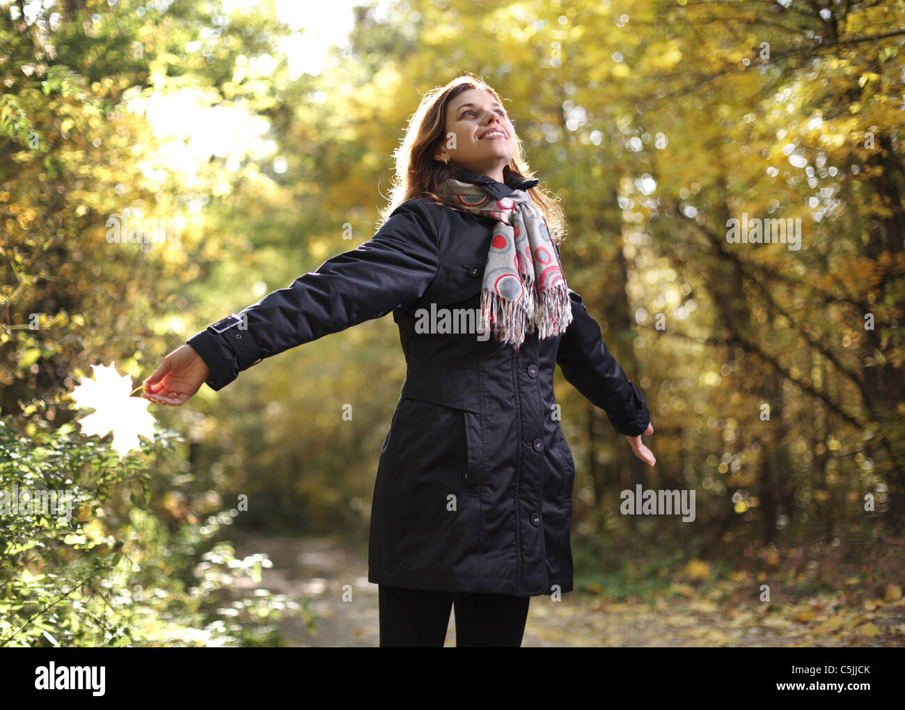 Giovane donna sorridente nel parco d'autunno. Foto Stock