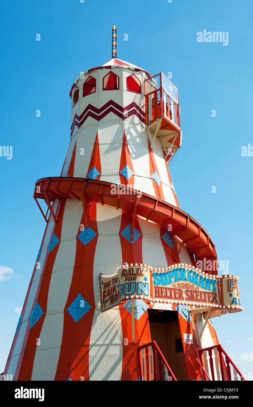 Helter Skelter fairground ride di fronte luminoso cielo blu Foto Stock