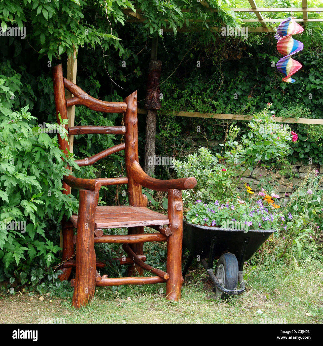 Scolpiti sedia in legno in un giardino Blisworth, REGNO UNITO Foto Stock