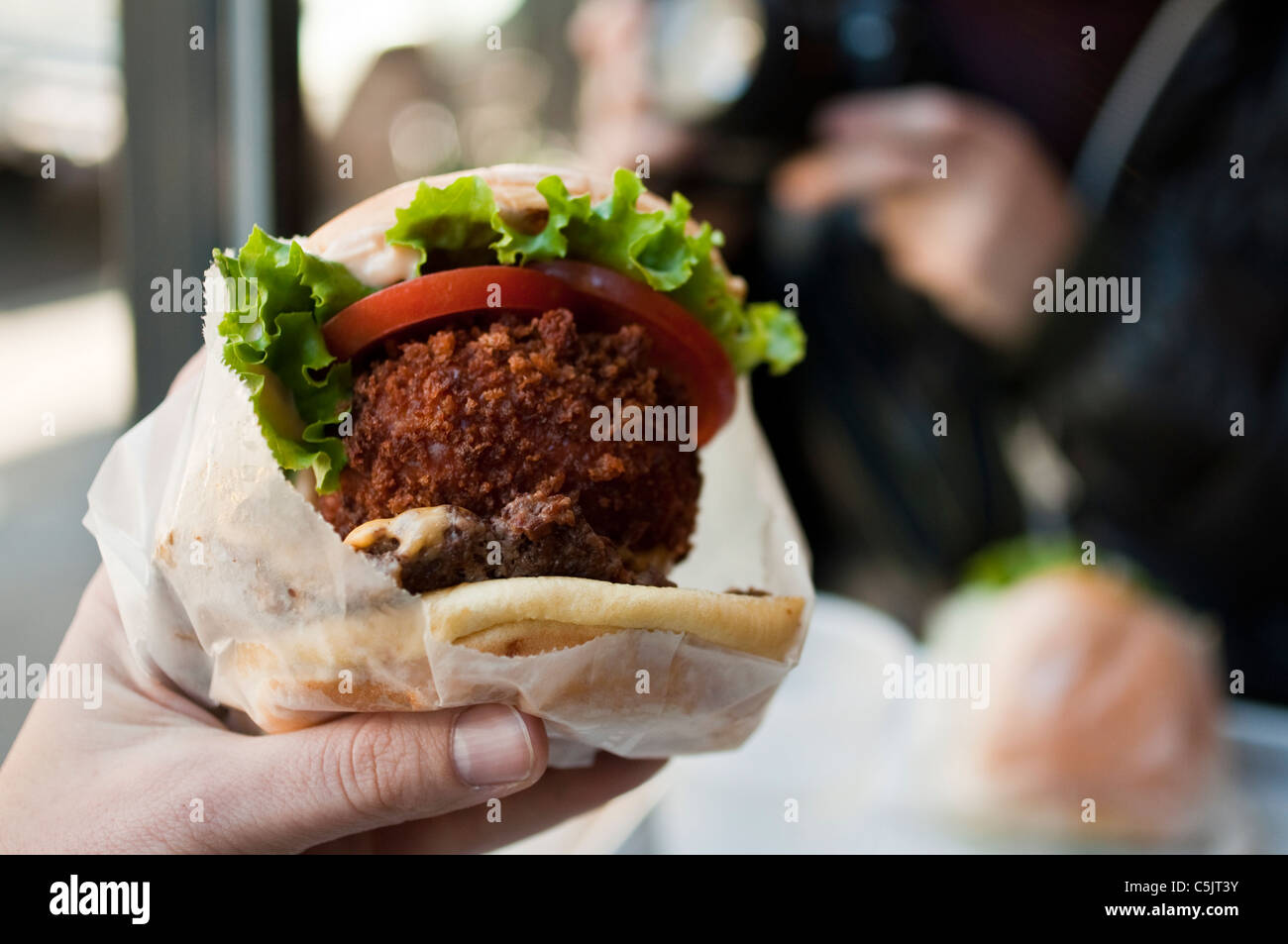 La Baracca pila in corrispondenza di Shake Shack in New York City - Cheeseburger e 'shroom burger e rabboccato con lattuga, pomodoro e salsa di Shack. Foto Stock