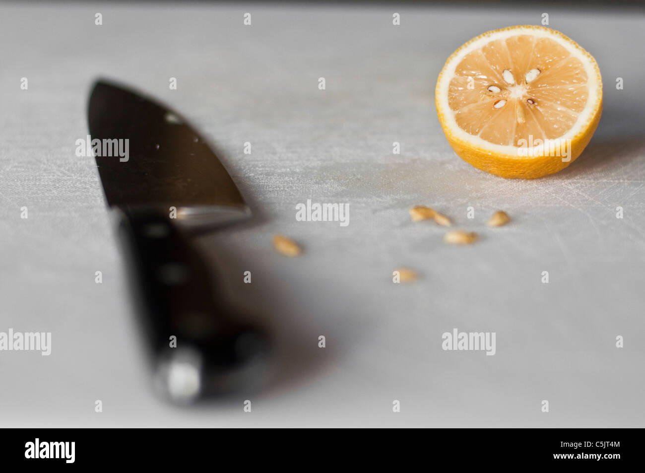 Un coltello e metà di limone su un taglio bianco bordo. Foto Stock