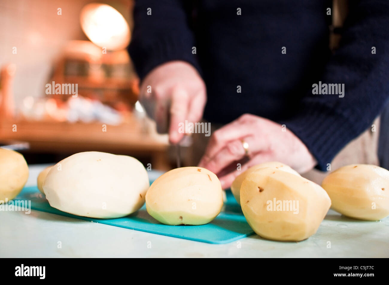 Una casa cucinare fette di patate pelate in cucina Foto Stock