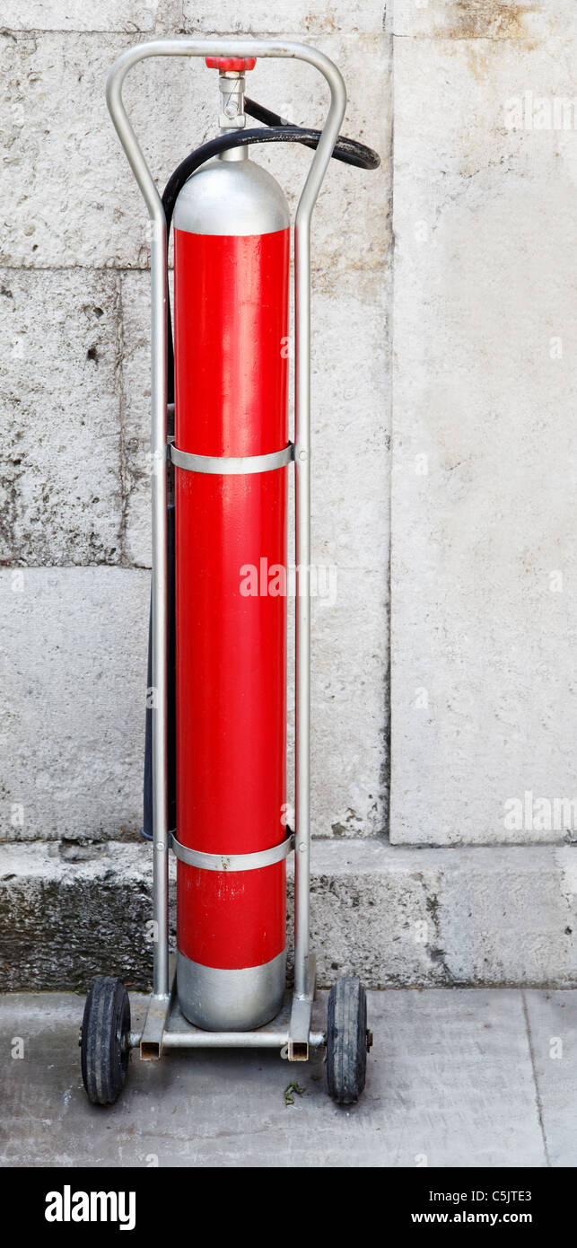 Equipaggiamento antincendio su un carro contro un muro di pietra calcarea Foto Stock
