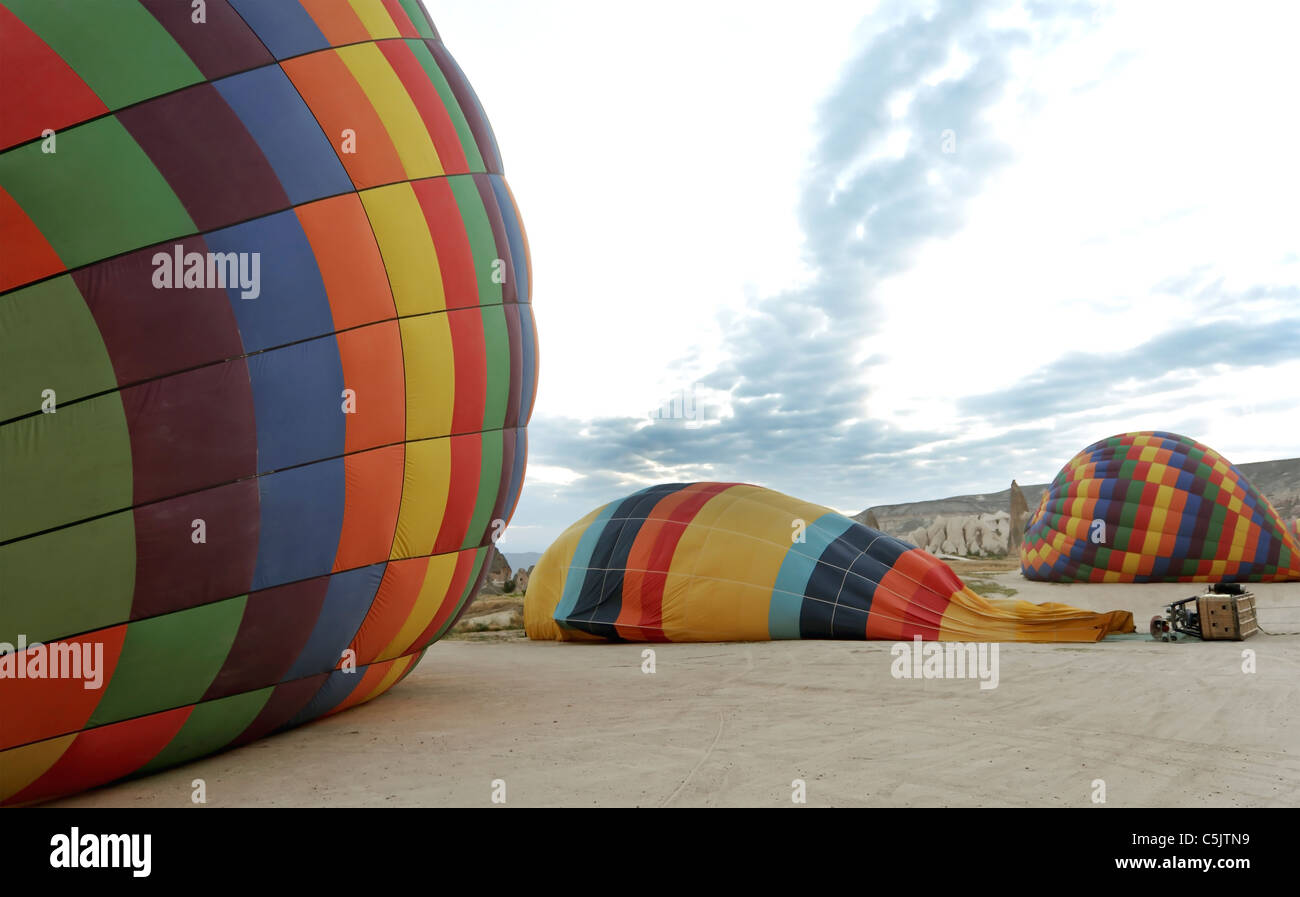 Preparare i palloni ad aria calda per battenti all'alba, colorato vista panoramica, contro la mattina presto le nuvole, scena orizzontale Foto Stock