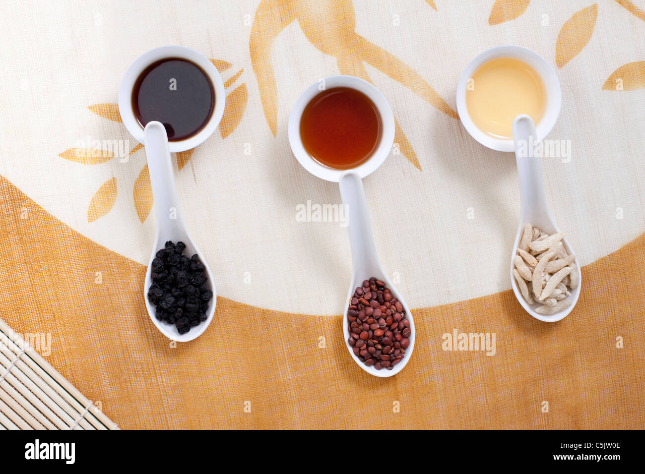 La medicina cinese in cucchiai in appoggio sul Teacups Foto Stock