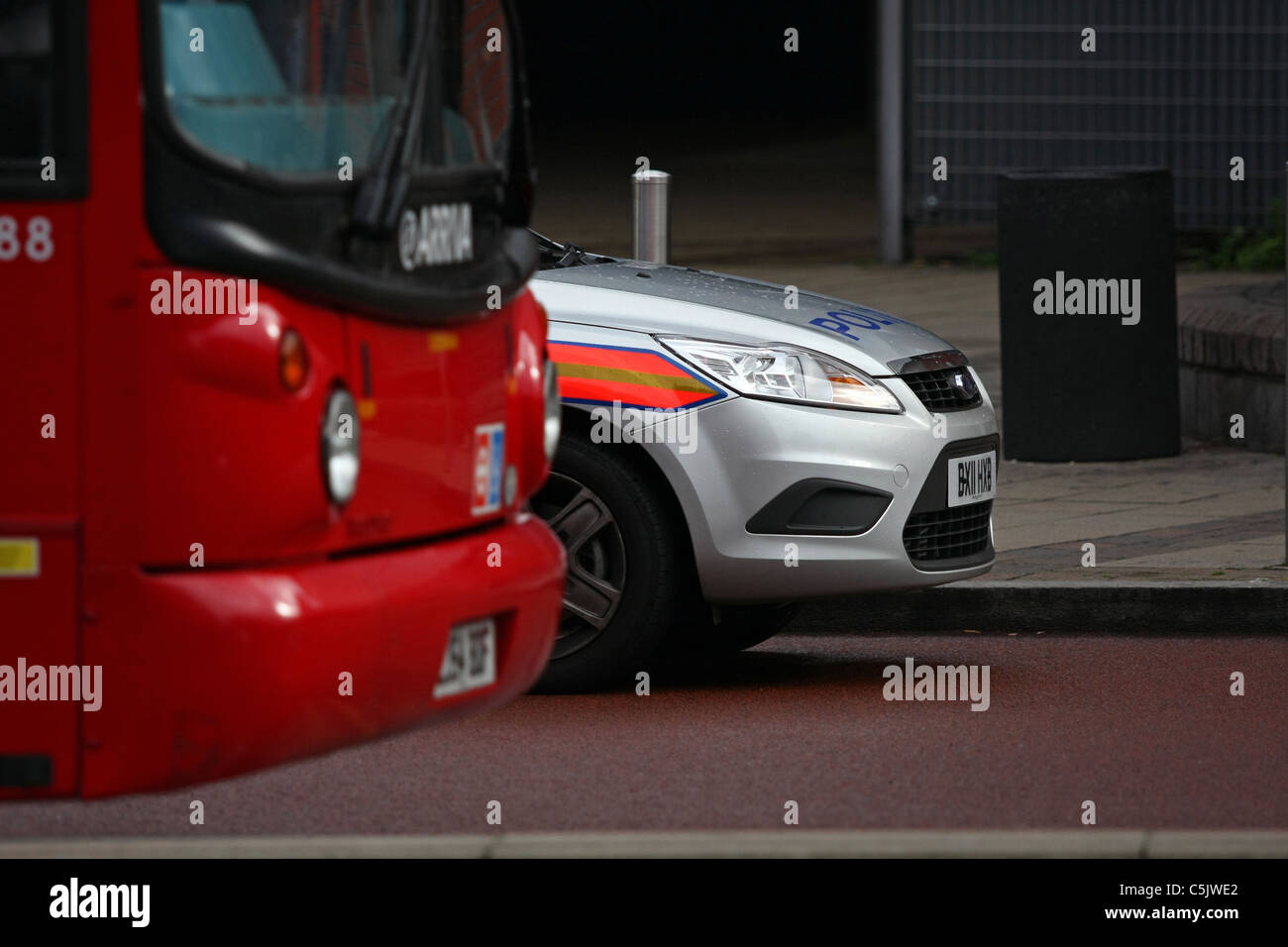 Il naso di una polizia parcheggiate auto accanto alla parte anteriore di un parcheggiato double decker bus in Londra Foto Stock