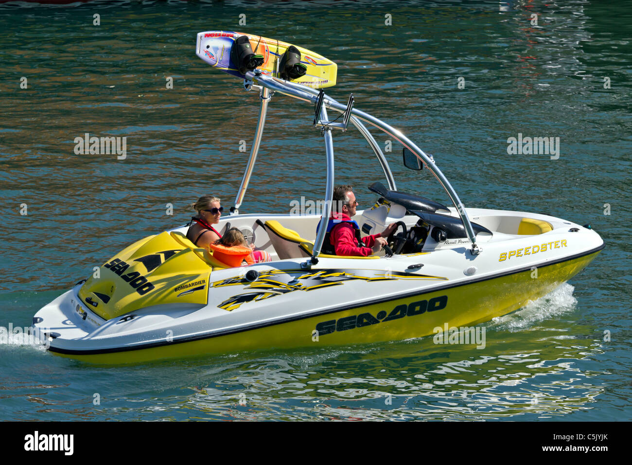 La famiglia in Barca sci che si diverte a Bombardier Seadoo Sea-Doo wakeboard fast jet boat andando lentamente Foto Stock