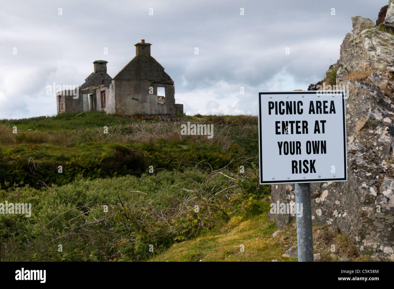 Un autentico segno accogliente per un area picnic avverte che esso deve essere utilizzato a proprio rischio e pericolo. Foto Stock