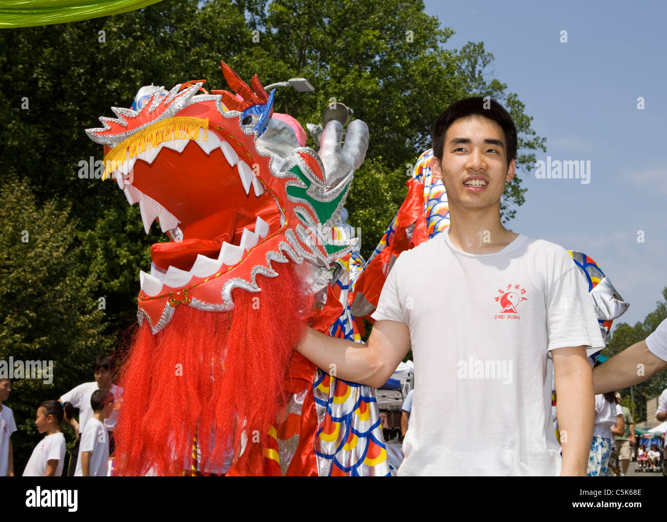 Un giovane cinese dragon dance performer tenendo la testa del dragone Foto Stock
