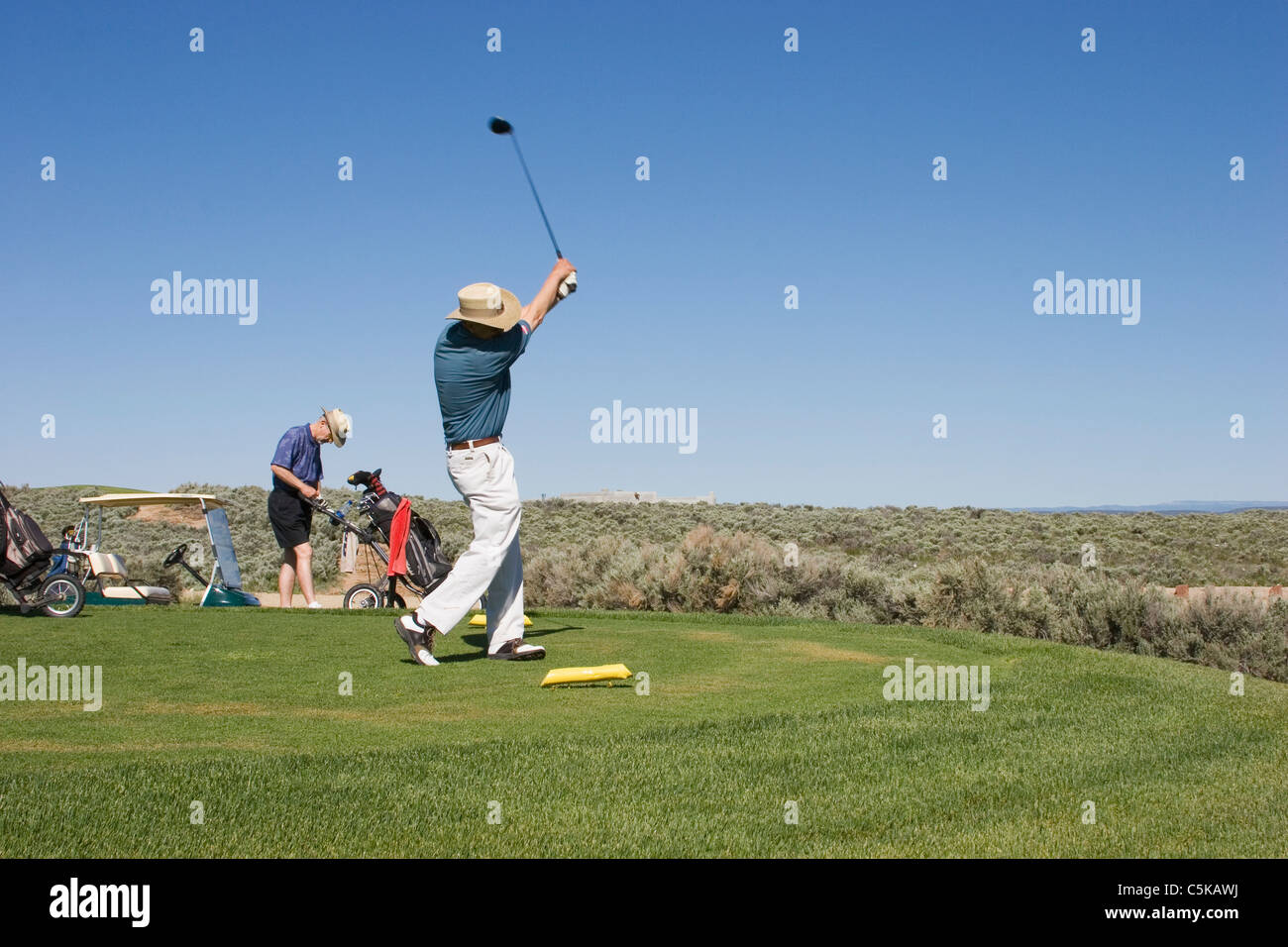 Due golfisti tee off di Taos Country Club Foto Stock
