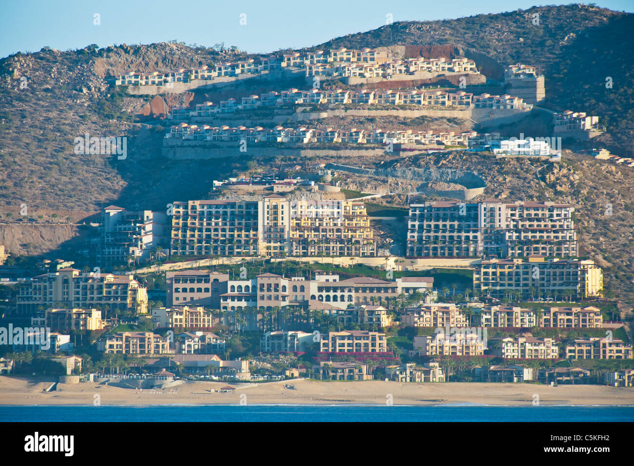 Centinaia di appartamenti, alberghi, case di città salire la pendenza dell'Oceano Pacifico a Cabo San Lucas, Messico. Foto Stock